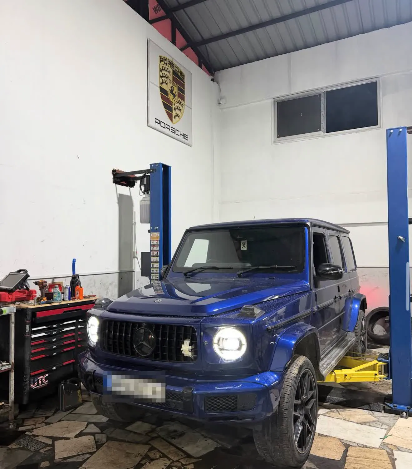 Atölyede kaldırıcıdaki mavi Mercedes G-Serisi